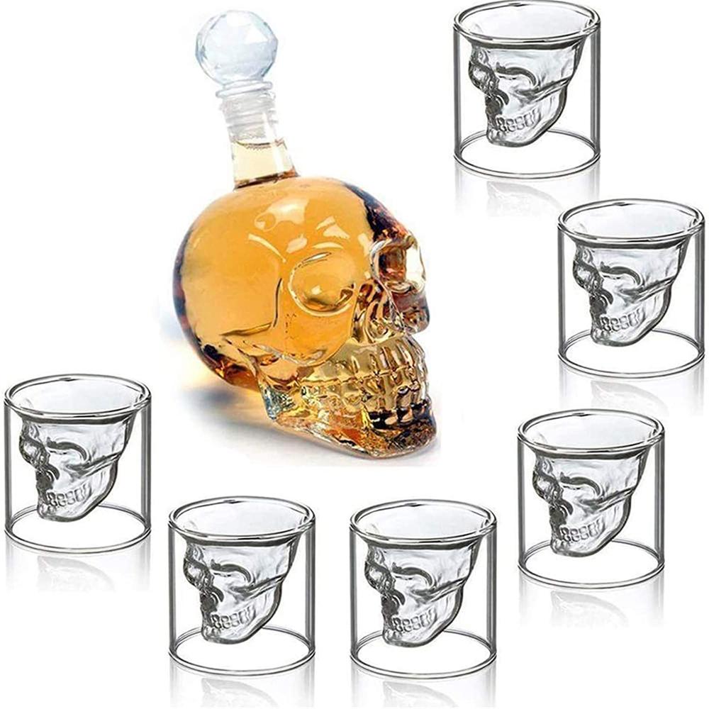 Skull-shaped decanter and shot glasses on a white background