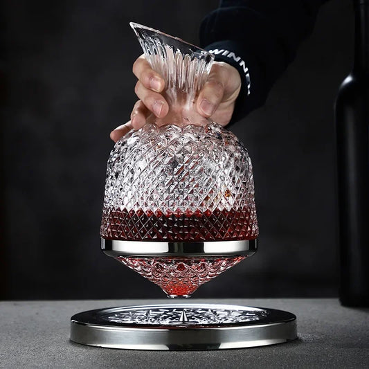 360 rotating decanter with wine being held up by a hand