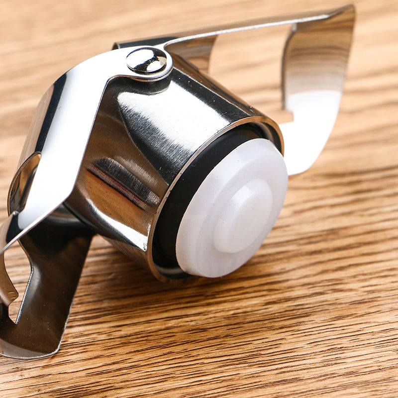 Stainless steel Champagne and sparkling wine bottle stopper on a wooden surface