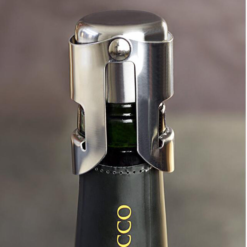 Close-up of a silver stainless steel Champagne and sparkling wine bottle stopper secured around the neck of a dark wine bottle