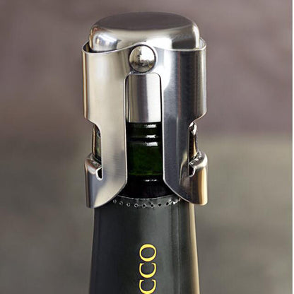 Close-up of a silver stainless steel Champagne and sparkling wine bottle stopper secured around the neck of a dark wine bottle