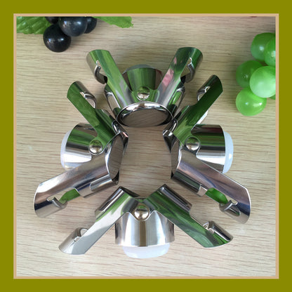 Stainless steel Champagne and sparkling wine bottle stopper with green accents on a wooden surface