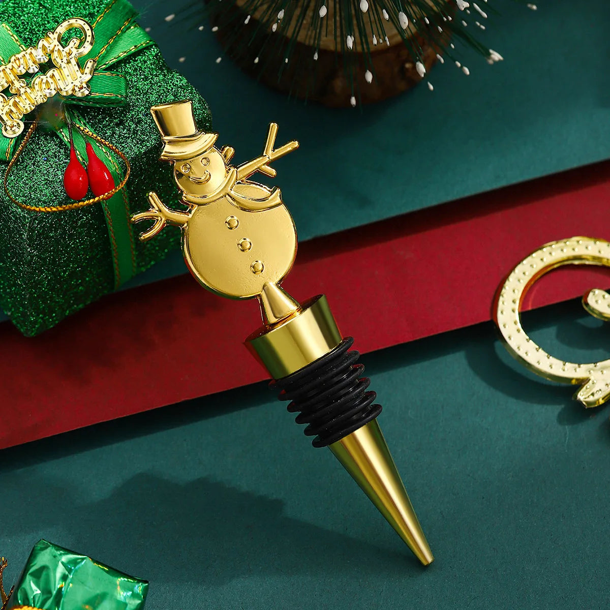 Gold snowman bottle stopper on a festive background with presents and decorations.