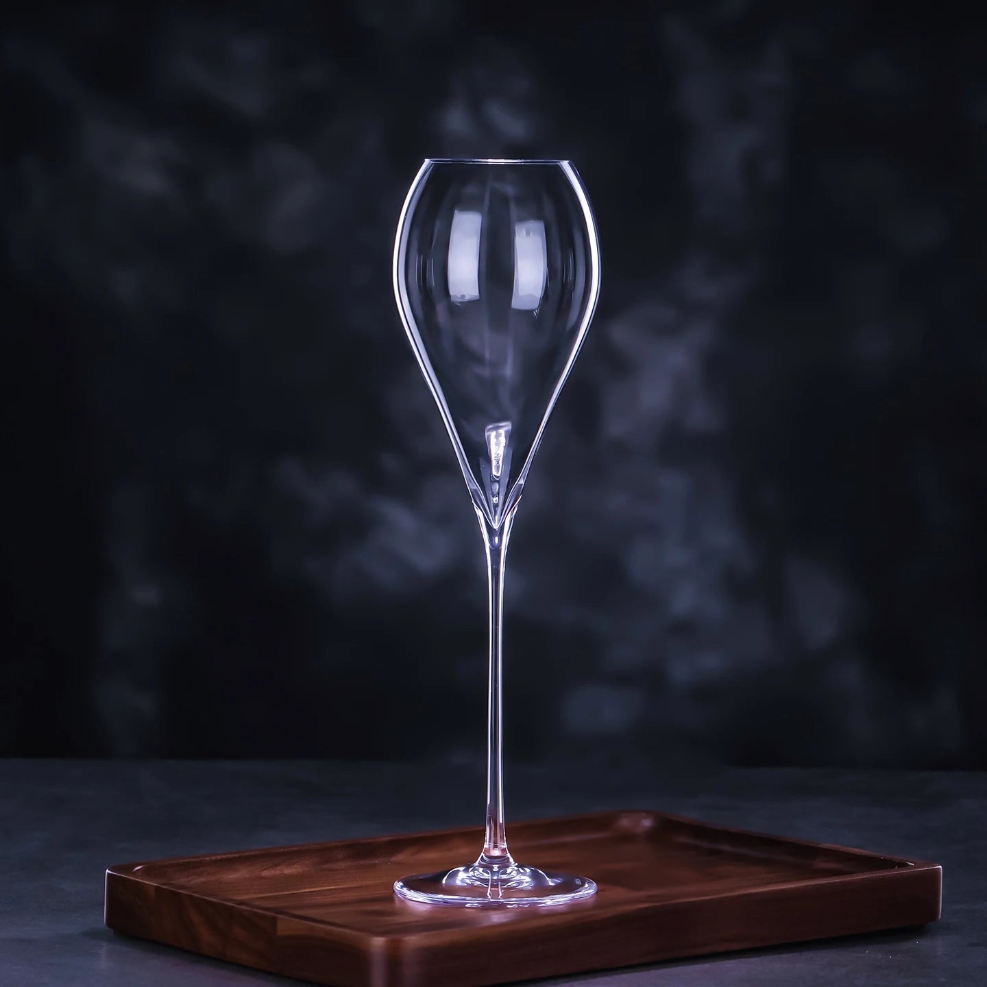 CRISON crystal wine glass on a wooden coaster against a dark background, highlighting elegant stemware for refined hosting and wine service