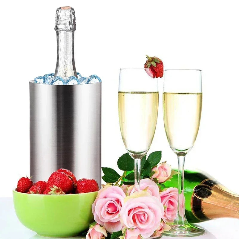 Champagne bottle chilled in a stainless steel wine cooler with two glasses, raspberries and flowers