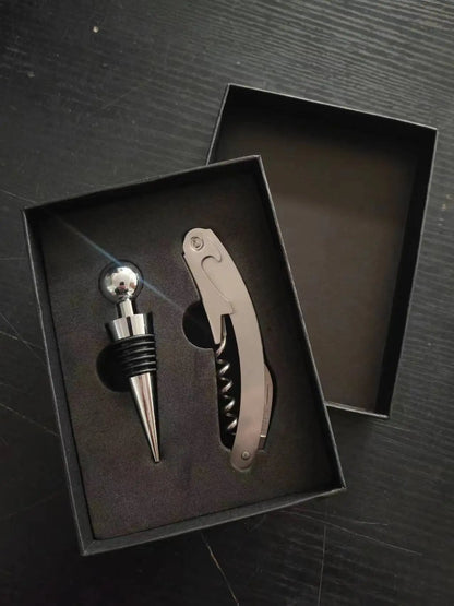 Wine bottle stopper and corkscrew set in a black box on a dark surface