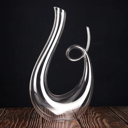 Sleek crystal wine decanter displayed on wooden surface with dark background for elegant presentation