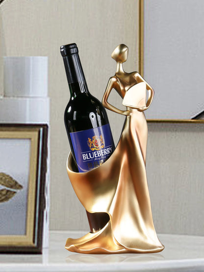 Gold decorative wine bottle holder holding a bottle of blueberry wine on an elegant decorative surface.