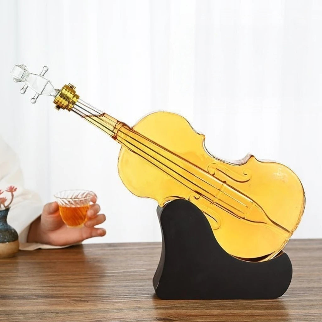 Glass violin-shaped decanter on a stand with a hand holding a whisky cup 