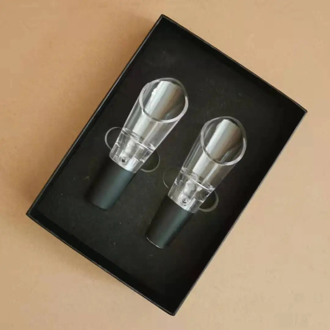 Two wine bottle stoppers in a black box on a beige background