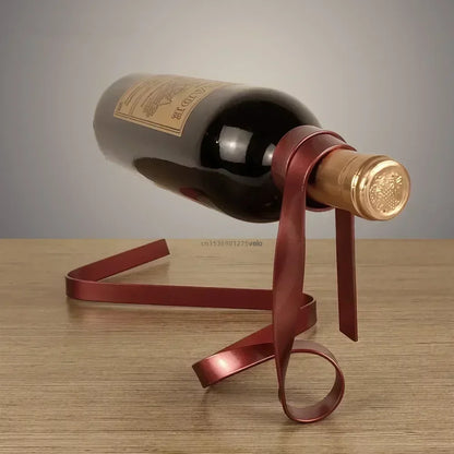 Wine bottle with a decorative red ribbon on a wooden surface