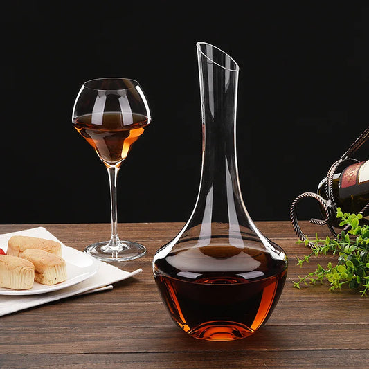 Handcrafted crystal wine decanter catching ambient light on a rustic bar.