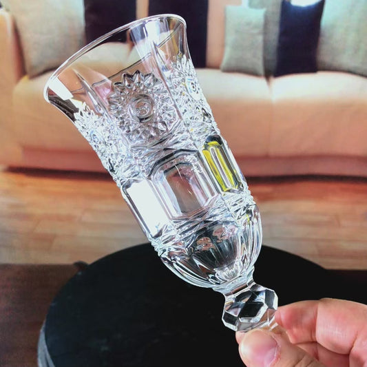 Elegant close-up video showcasing the full design of a crystal champagne flute, highlighting its slender silhouette, refined stem, and brilliant clarity as light reflects through the glass in a luxury wine presentation setting.